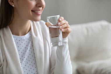 Gülümseyen güzel bir genç kadın elinde bir bardak su tutuyordu.