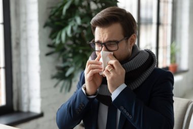 Sıcak eşarp takan hasta çalışanın burnunu sümkür.