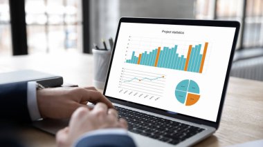 Dizüstü bilgisayar kullanarak proje istatistikleriyle çalışan iş adamlarını kapat