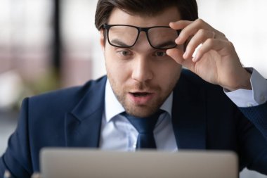 Şok olmuş işadamı gözlüğünü çıkarıp beklenmedik haberler okuyor.