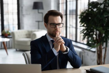 Gözlük takan düşünceli bir işadamı problem çözümünü düşünüyor.