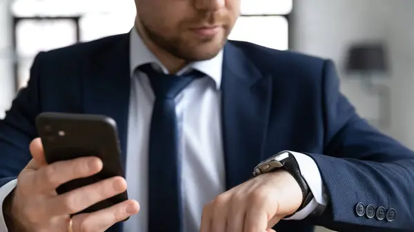 Close up confident businessman holding smartphone, checking time, planning — Stock Photo, Image