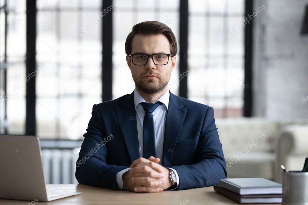 Head shot portrait confident businessman wearing glasses sitting at desk