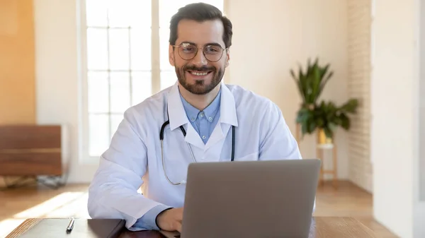 Široký portrét usmívajícího se lékaře na pracovišti — Stock fotografie