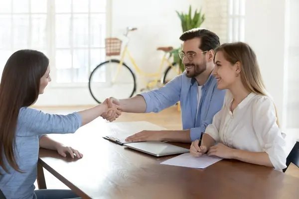 I reclutatori sorridenti chiudono l'affare con cliente femminile alla riunione — Foto Stock