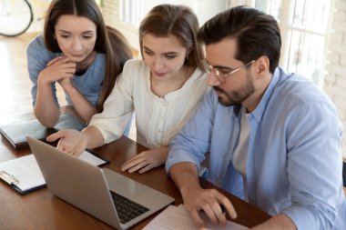 Çeşitli meslektaşlar toplantıda bilgisayarda birlikte çalışıyorlar