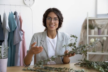 Genç kadın vlogger çiçek tasarımcısı çiçek kompozisyonunun temellerini açıklıyor