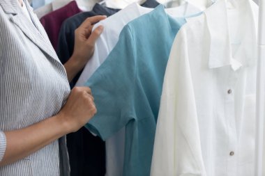 Giyim mağazasının bayan müşterisi yeni koleksiyondan kıyafet seçiyor