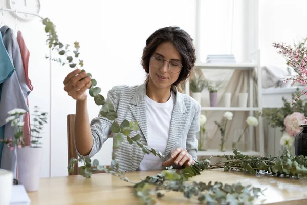 Mulher pensativo hábil em florística olhando ramo imaginando composição — Fotografia de Stock