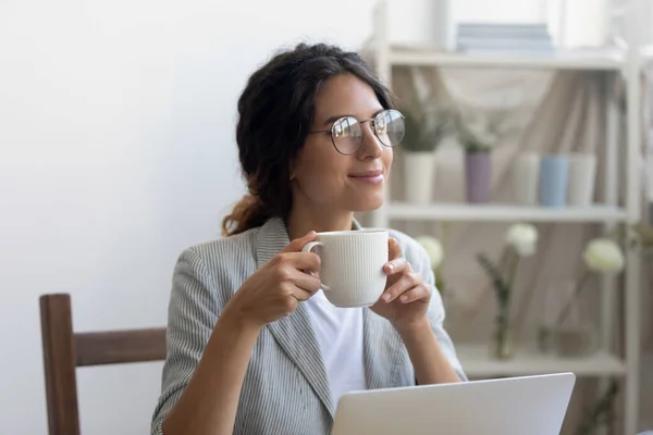 Female designer drinking coffee satisfied with self realization in profession