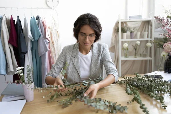 Young woman florist working on floral bunch by customer order — Stock Photo, Image