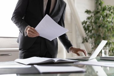 Bilgisayarda kağıt belgelerle birlikte iş adamlarının çalışmalarını kapat.