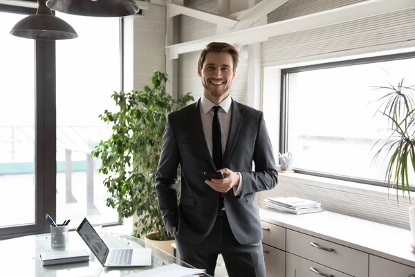 Porträtt av leende ung affärsman poserar i ämbetet — Stockfoto