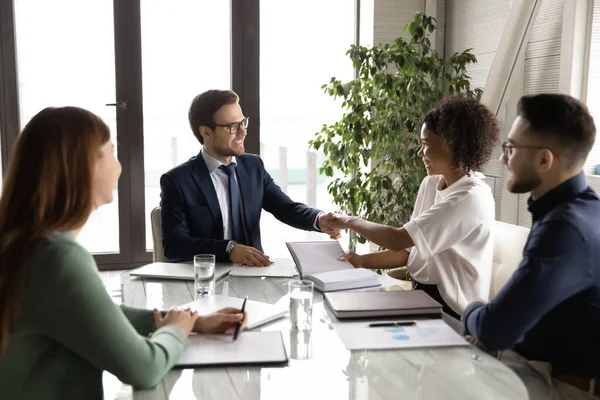 Smiling international businesspeople handshake closing deal at meeting — Stock Photo, Image