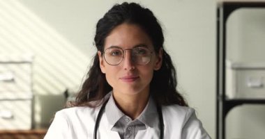 Beyaz önlüklü ve gözlüklü güzel bir doktorun portresi.