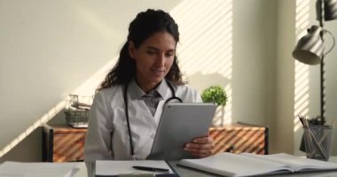 Pratisyen hekimler iş yerinde modern tablet cihazını kullanarak çalışırlar.