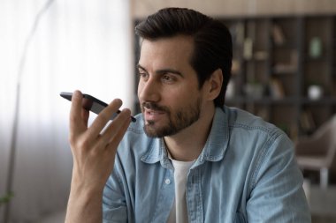Beyaz adam akıllı telefondan sesli mesaj kaydetti.