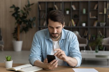 Beyaz adam evde modern akıllı telefon kullanıyor.