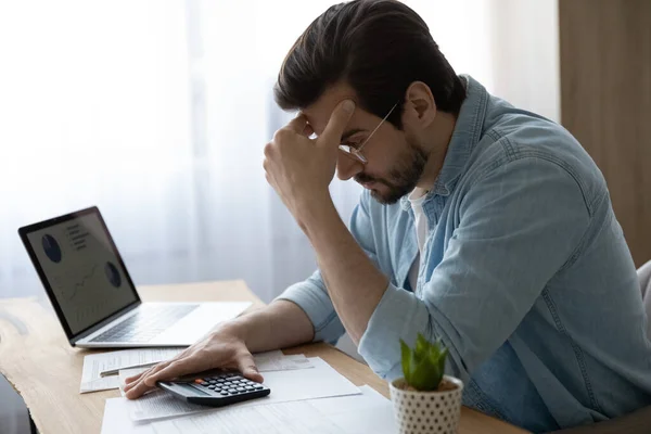 Pensiv ung man beräkna hushållskostnader tänkande — Stockfoto