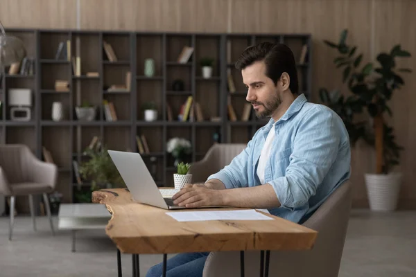 Caucasian man work online on laptop at home office