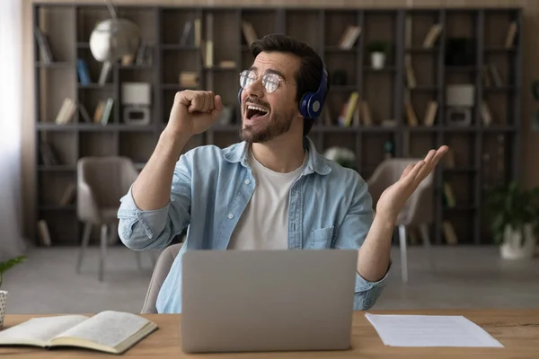 Overgewaardeerde man in hoofdtelefoon luistert naar muziek op het werk — Stockfoto