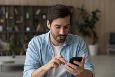 Sersemlemiş genç adam akıllı telefondan gelen iyi haberle şok oldu.