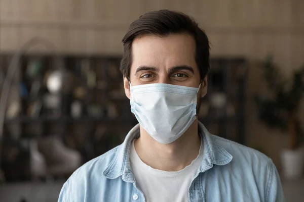 Portrait of smiling man in medical facemask posing