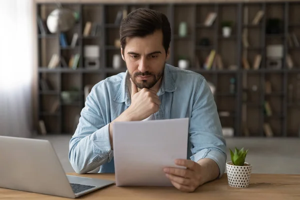 Pensive Caucasian man read paperwork letter at home — Stock Photo, Image