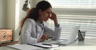 Doktor dizüstü bilgisayar ekranına bakıyor ve kötü haber okuyor.