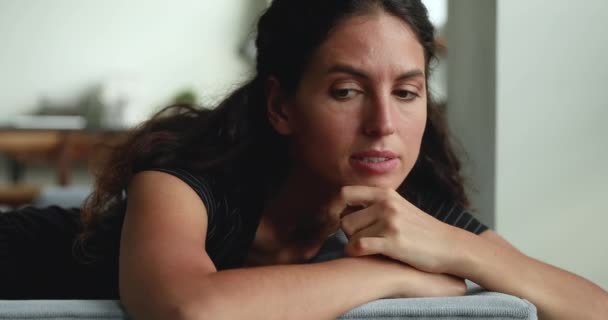 Грустная женщина, лежащая на диване и испытывающая личные проблемы, чувствует себя несчастной — стоковое видео