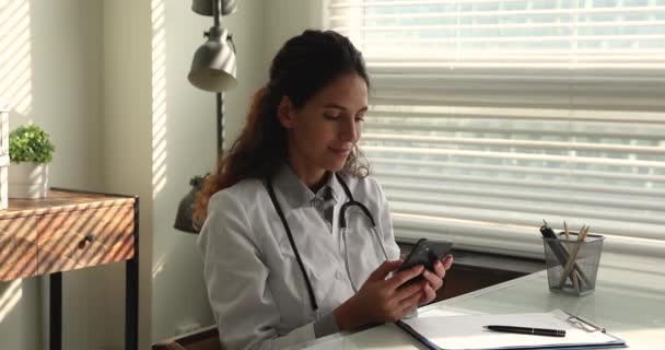 Терапевт держит смартфон с помощью медицинского приложения для врачей — стоковое видео