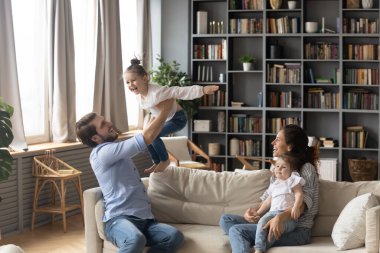 Mutlu ebeveynler evde küçük kızlarıyla eğleniyor.