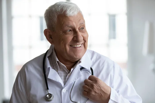 Optimista médico senior sonriendo tener buenas noticias para el paciente —  Fotos de Stock