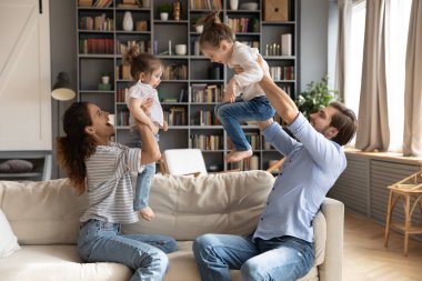Mutlu ebeveynler heyecanlı küçük kızlarla oynarlar.