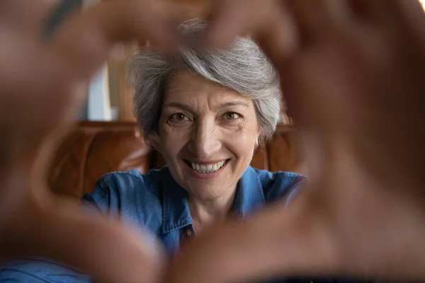 Close up felice donna di mezza età bella facendo gesto del cuore. — Foto Stock