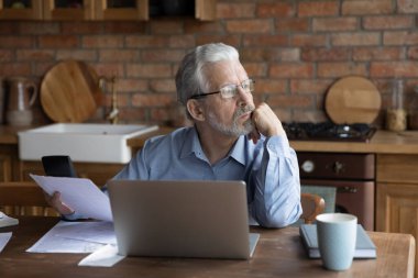 Gözlüklü düşünceli yaşlı adam uzaktan bakıyor..