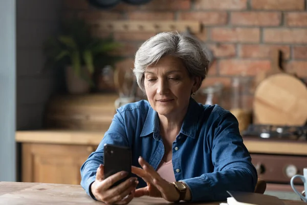 Счастливая пожилая женщина использует приложения для смартфонов. — стоковое фото