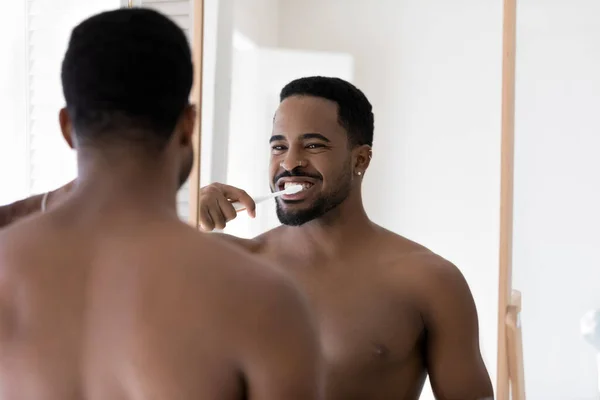Щасливий молодий афроамериканський голий чоловік чистить зуби . — стокове фото