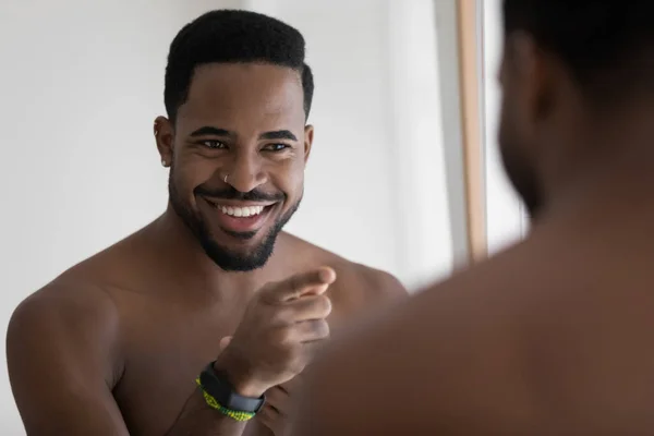 Glücklicher junger gutaussehender afrikanischer ethnischer Mann stimmt sich auf positiven Tag ein. — Stockfoto