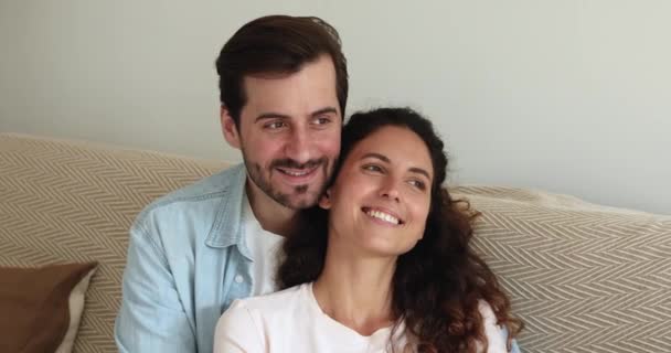 Happy dreamy peaceful young family couple relaxing on comfortable sofa. — Stock Video