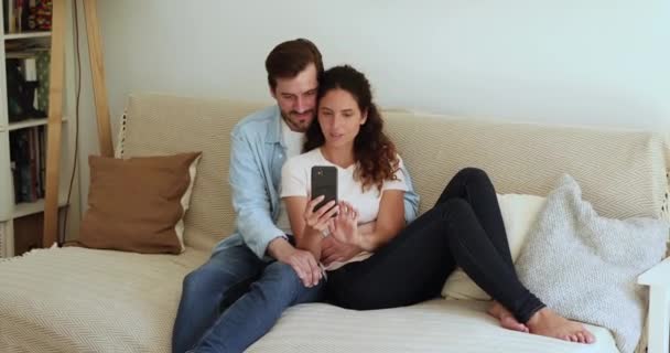 Ευτυχισμένο στοργικό οικογενειακό ζευγάρι που χρησιμοποιεί το smartphone. — Αρχείο Βίντεο