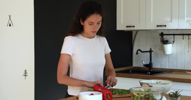 Fröhliche junge Frau hackt frisches Gemüse an Bord. — Stockvideo