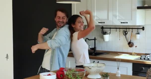 Överlycklig ung gift familj par dansar i köket. — Stockvideo