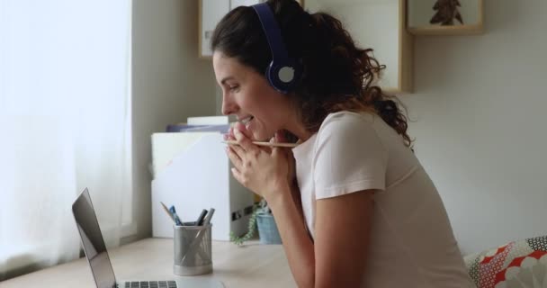 Glad ung europeisk kvinna i hörlurar ger online-klass. — Stockvideo