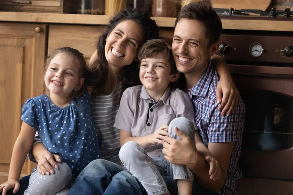 Casal com crianças posando para retrato de família dentro de casa olhando para o lado — Fotografia de Stock