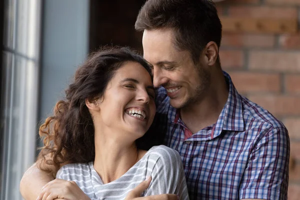 Zorgzame jonge man knuffelen schouders van geliefde vrouw met genegenheid — Stockfoto