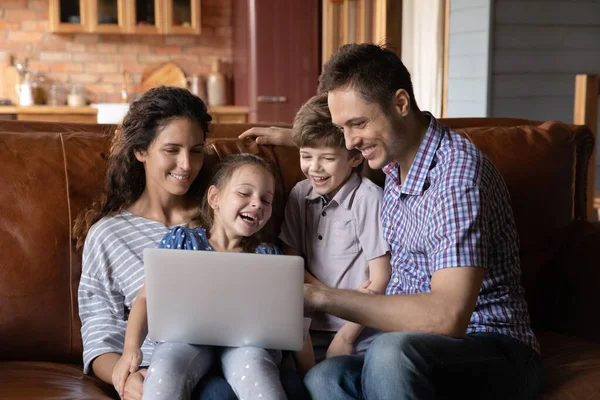 Mom dad two children hugging on couch using laptop pc — Stock Photo, Image