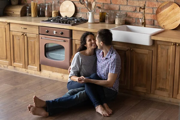Люблячий чоловік сидить на теплій підлозі тримає дружину на колінах — стокове фото