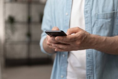 Akıllı telefon tutan erkek eller algılayıcı ekranı tarayan internete dokunuyor