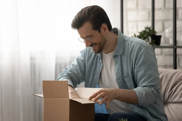 Jongeman trouwe klant van de postdienst unboxing kleine pakket — Stockfoto